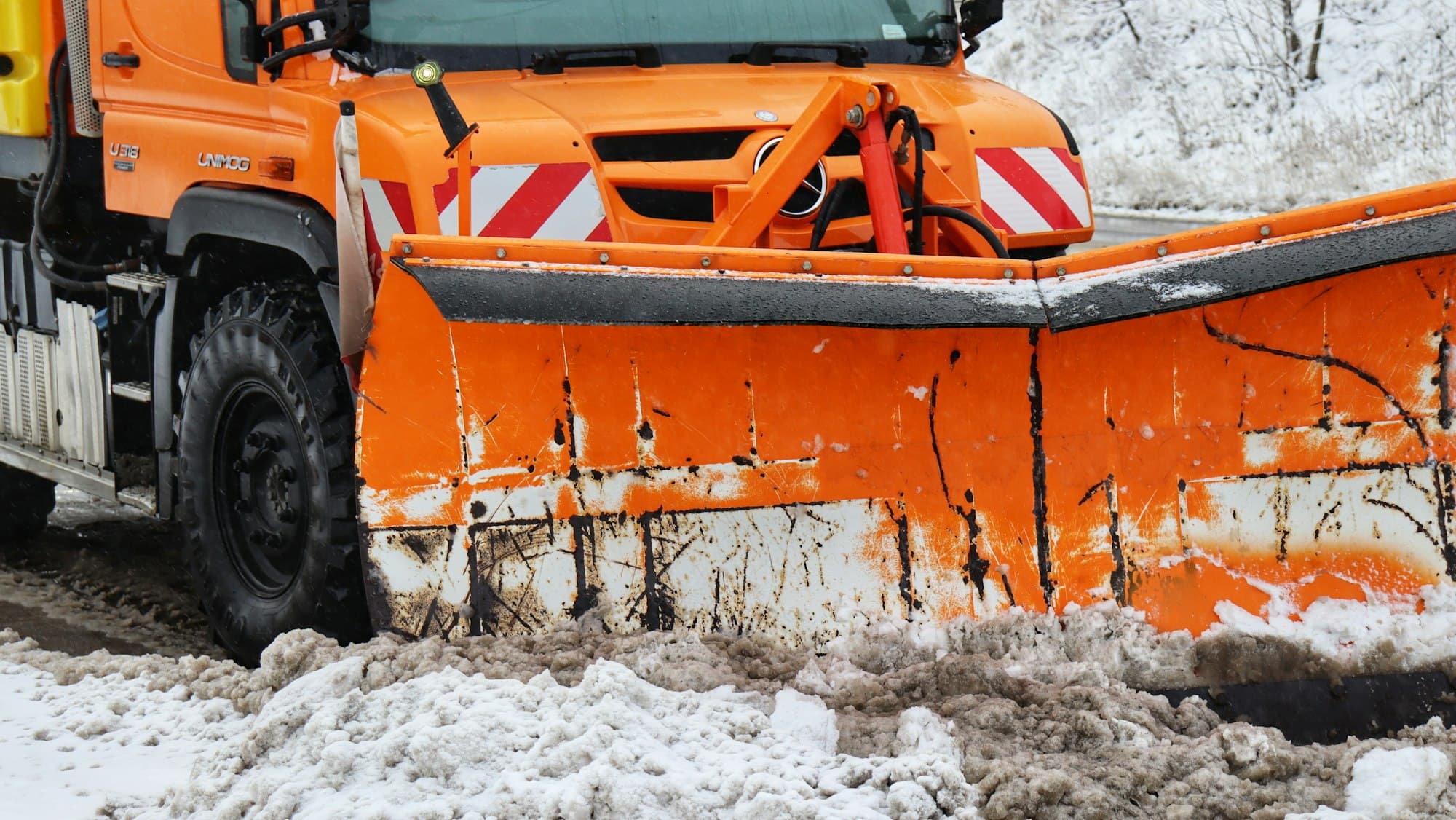 Oranges Räumschild eines Winterdienstfahrzeugs in Nahaufnahme