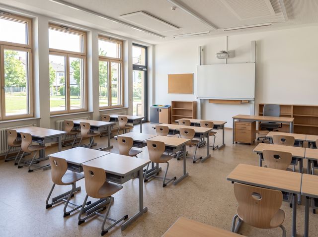 Helles Klassenzimmer mit neuen Schultischen und Stühlen