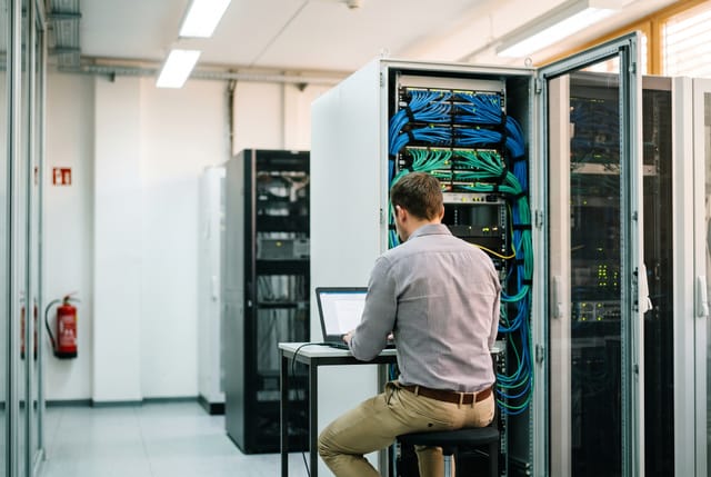 Techniker vor einem offenen Rack im kommunalen Rechenzentrum