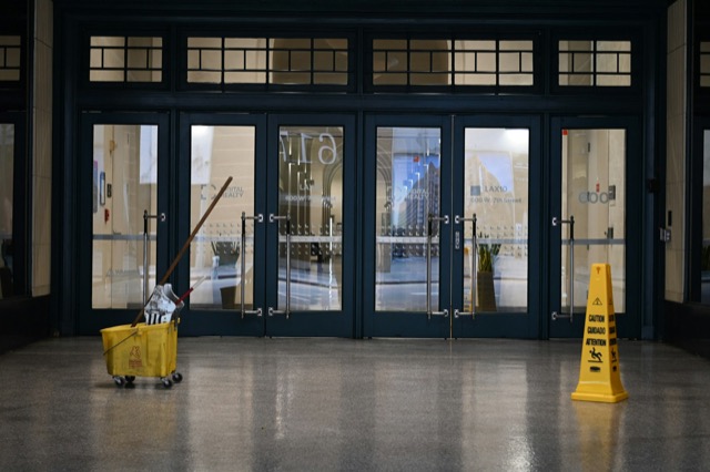Moppeimer und Warnschild vor einer Glastür